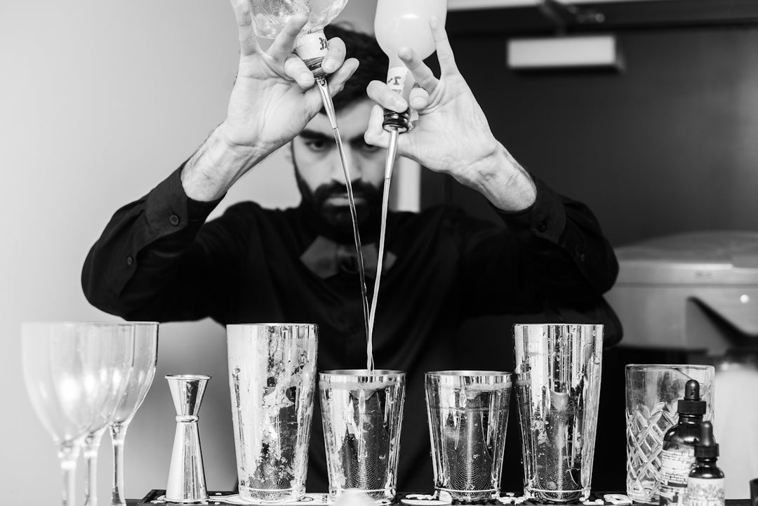 a man in a black shirt is making a drink
