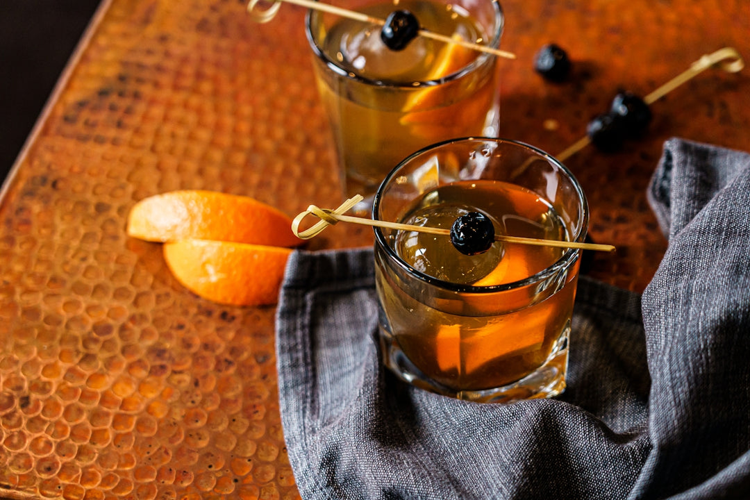 a couple of glasses filled with drinks on top of a table