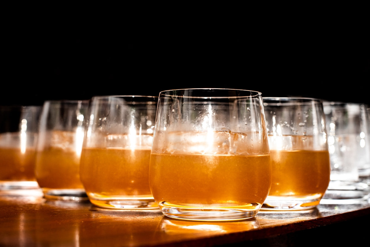 a row of glasses filled with liquid sitting on top of a table