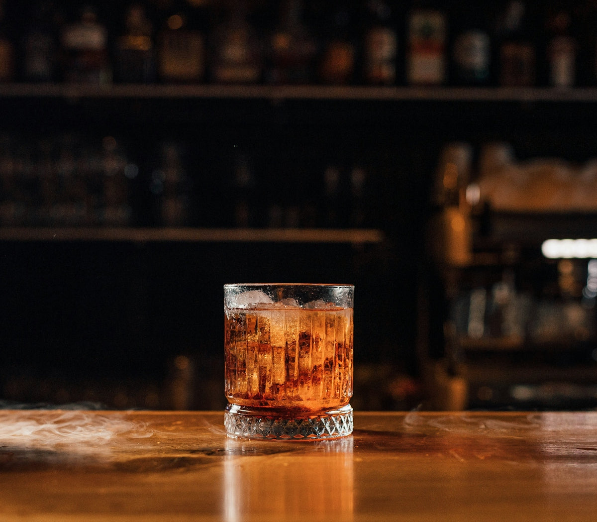 a glass filled with liquid sitting on top of a wooden table