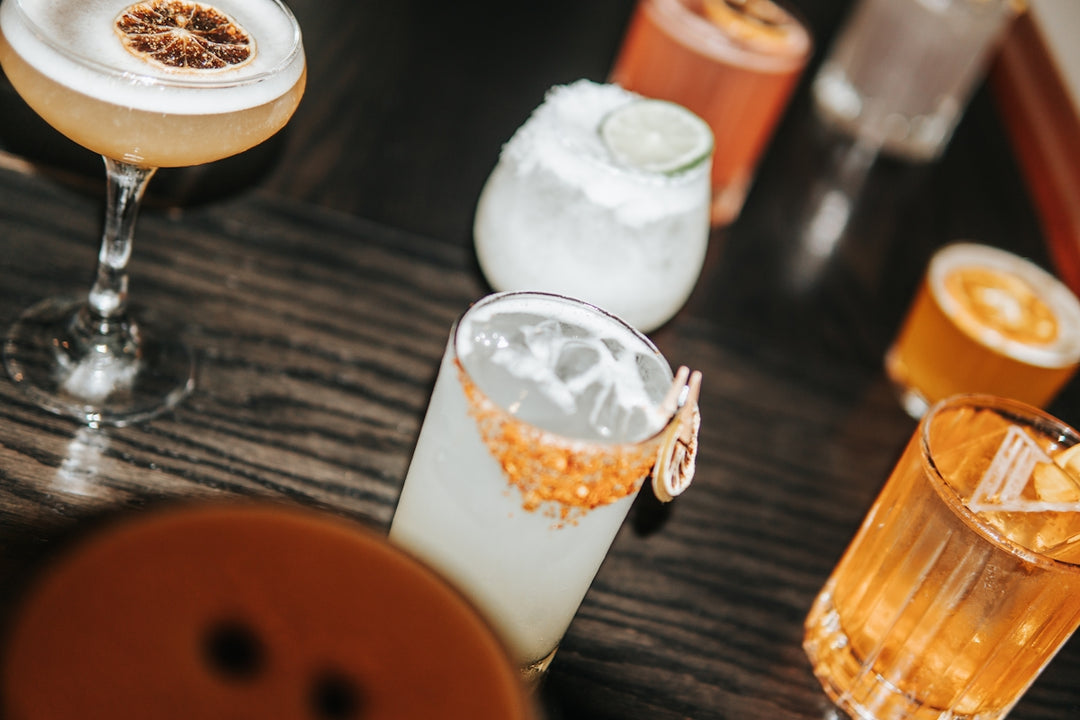 a wooden table topped with different types of drinks