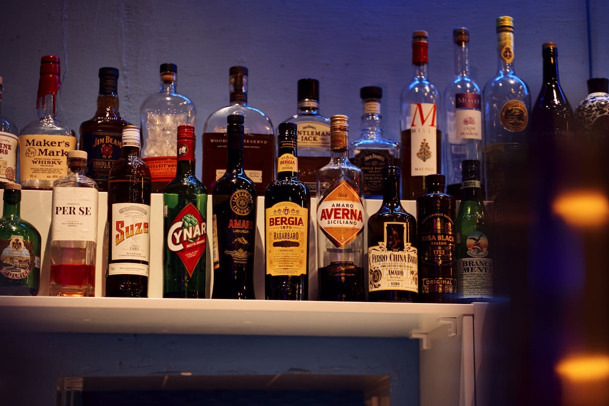 a bunch of liquor bottles are lined up on a shelf