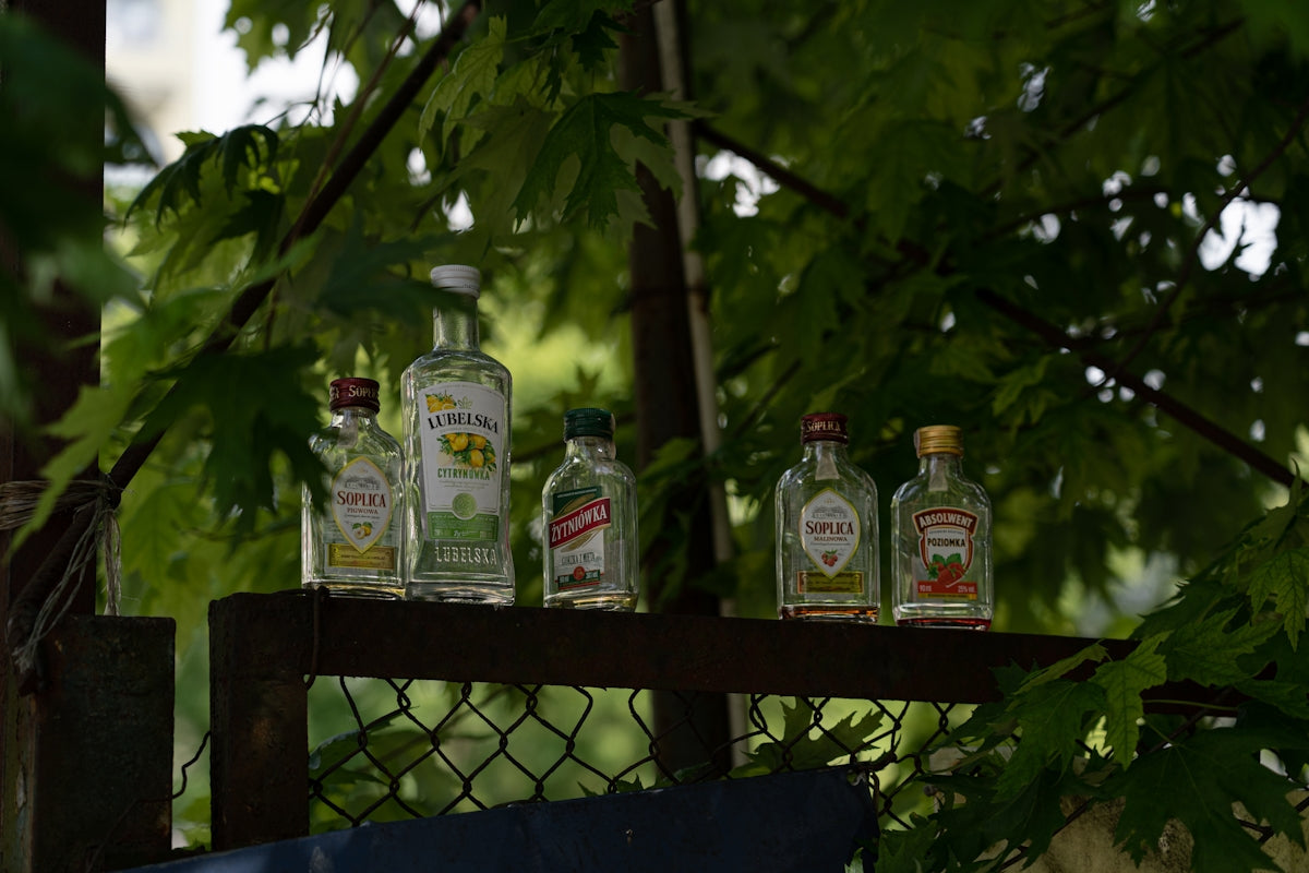 a group of bottles sitting on top of a wooden shelf