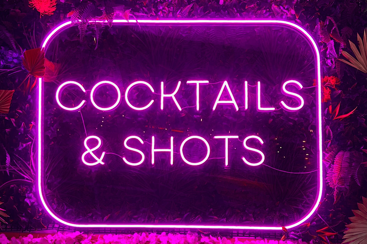 A neon sign that says cocktails and shots