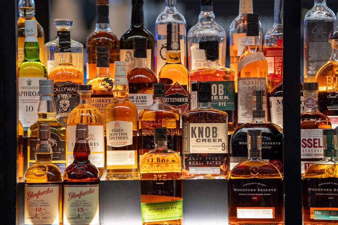 Many bottles of alcohol are arranged on shelves.