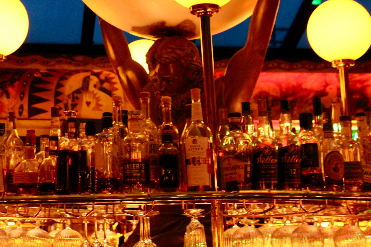 Bottles of alcohol on a bar shelf with lights.