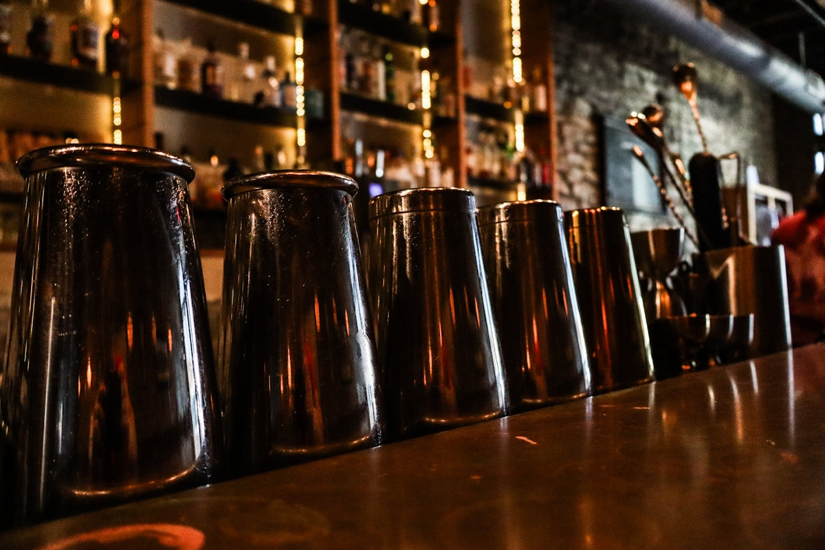 Row of cocktail shakers on a bar counter