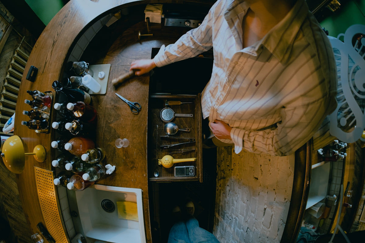 Person reaching into a wooden cabinet with tools.