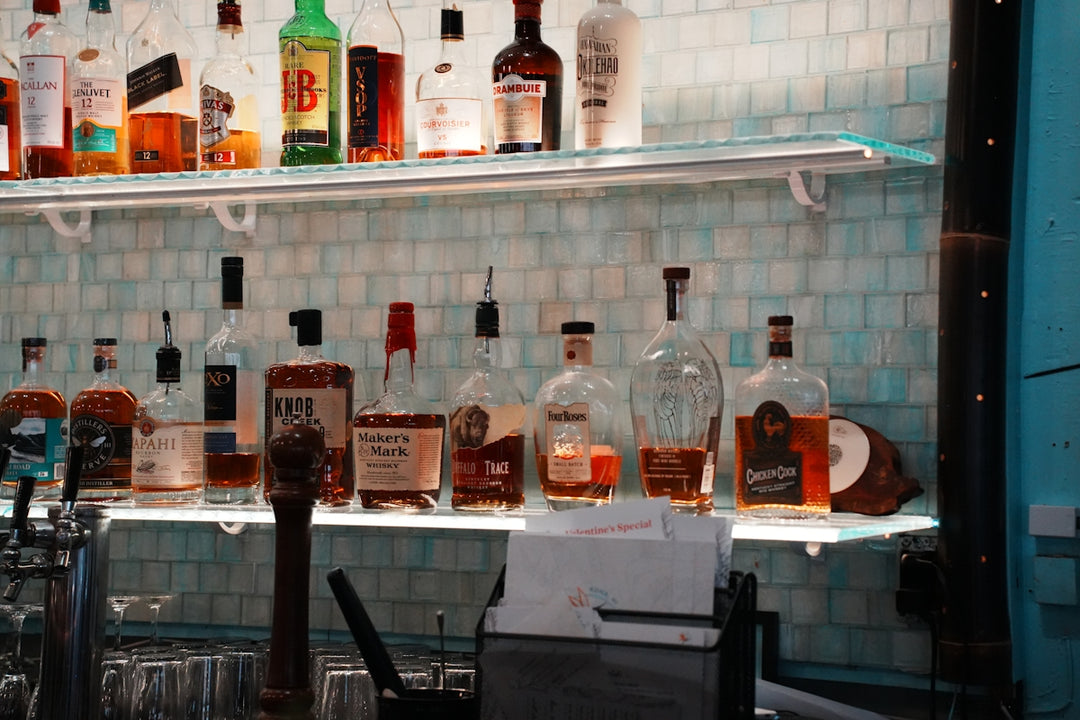 Assortment of liquor bottles displayed on bar shelves