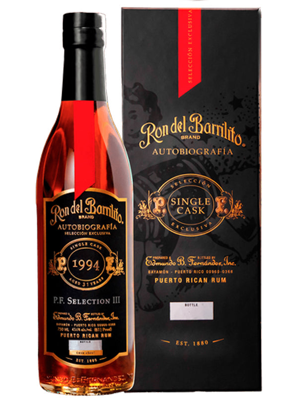 Bottle of Ron del Barrilito rum with its packaging on a white background